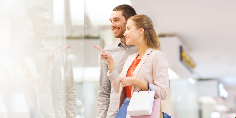 woman in bathrobe standing in front of hanger rack and trying to choose outfit dressing